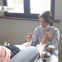 Instruktorka podologii pokazująca kursantce nowoczesną technikę zabiegową podczas szkolenia.